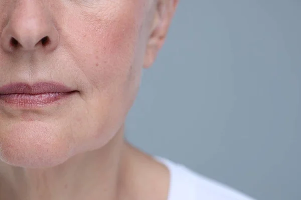 老年妇女的皮肤在灰色背景 特写和文字空间老化 康复治疗 — 图库照片