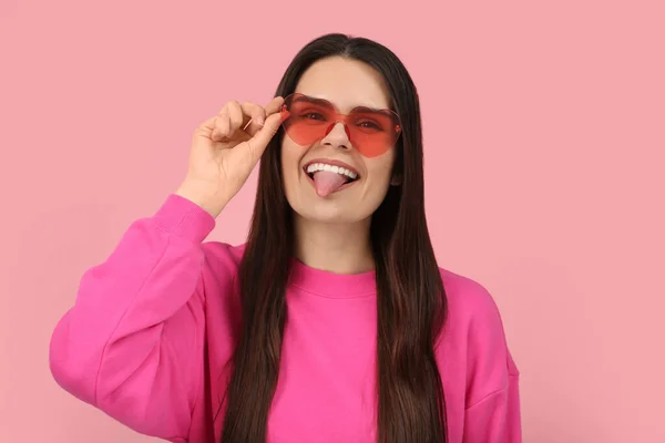 Szczęśliwa Młoda Kobieta Kształcie Serca Okulary Pokazujące Jej Język Różowym — Zdjęcie stockowe