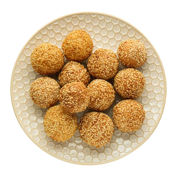 Plate of delicious sesame balls on white background, top view