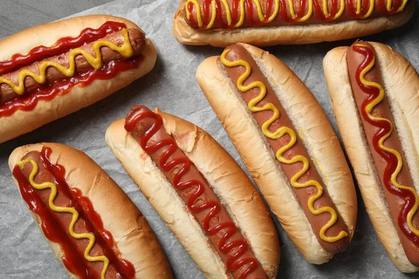 Verse Heerlijke Hotdogs Met Sauzen Perkamentpapier Plat Gelegd — Stockfoto