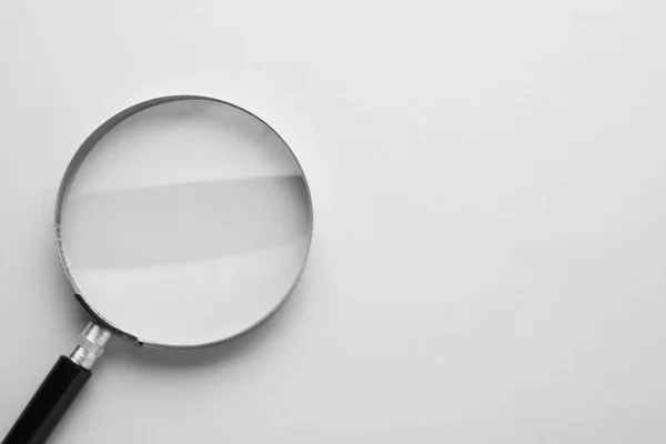 stock image Magnifying glass on light grey background, top view. Space for text