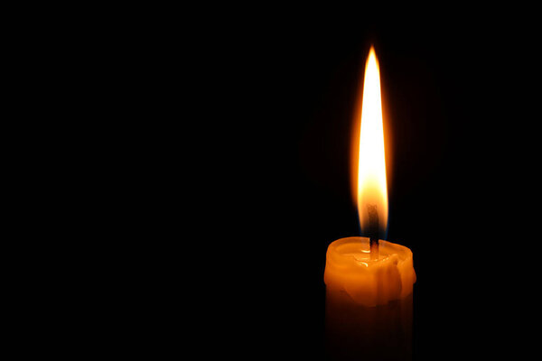 Burning candle on black background, closeup. Space for text