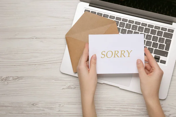 Przeprosiny Kobieta Trzymająca Kartę Słowem Przepraszam Pobliżu Koperty Laptopa Przy — Zdjęcie stockowe