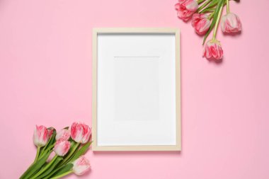 Boş fotoğraf çerçevesi ve pembe arka planda güzel lale çiçekleri. Tasarım için boşluk