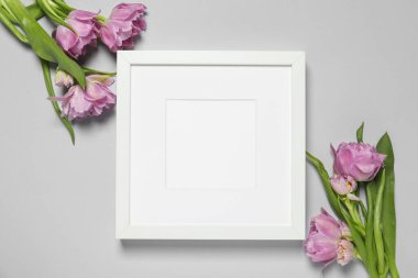 Boş fotoğraf çerçevesi ve açık gri arka planda güzel lale çiçekleri. Tasarım için boşluk