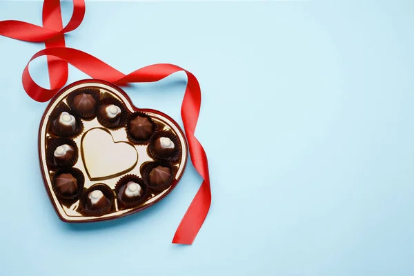 Caixa Forma Coração Com Deliciosos Doces Chocolate Fita Fundo Azul — Fotografia de Stock