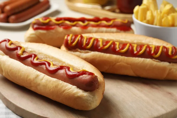 Čerstvé Lahodné Hot Dogy Omáčkou Dřevěné Desce Detailní Záběr — Stock fotografie