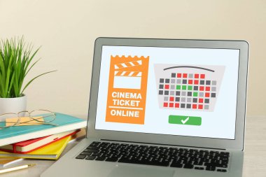 İnternetten sinema bileti almak. Masada açık web sitesi ya da uygulaması olan dizüstü bilgisayar