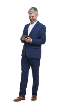 Beyaz arka planda akıllı telefon kullanan şık giyinmiş olgun bir işadamı.