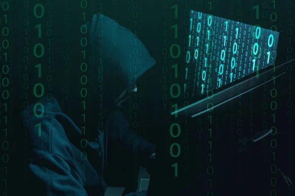 Anonymous man with computers and binary code in darkness