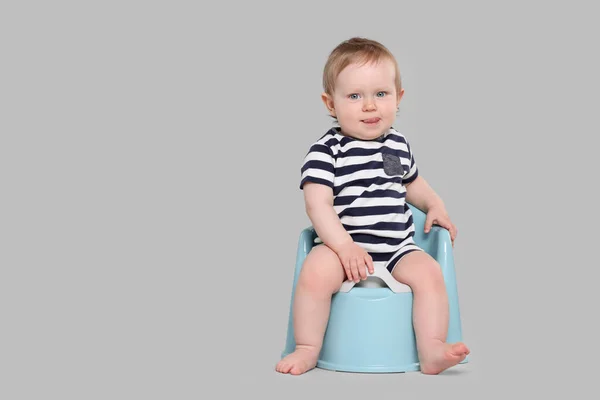 stock image Little child sitting on baby potty against light grey background, space for text