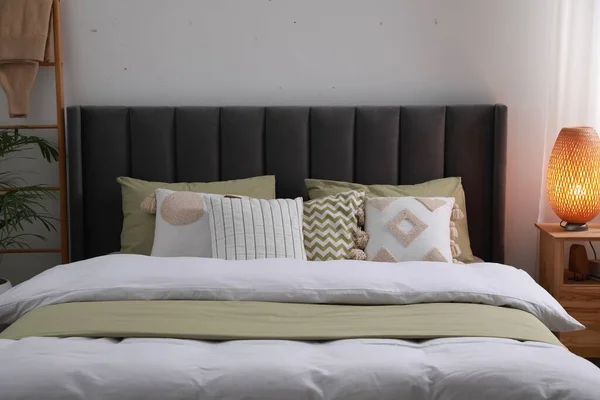 Yastıklı Rahat Bir Yatak Odadaki Ahşap Komodinin Üzerinde Lamba Şık — Stok fotoğraf