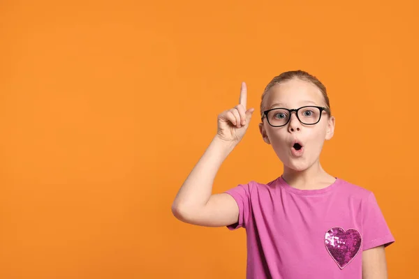 stock image Portrait of cute girl in glasses on orange background. Space for text