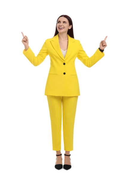 白い背景に何かを指して黄色のスーツの美しいビジネス女性 — ストック写真