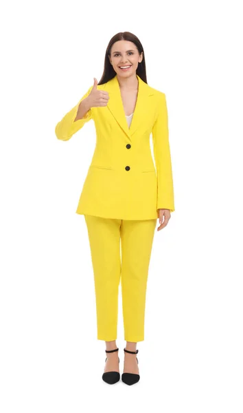 漂亮而快乐的女商人 穿着黄色西装 大拇指插在白色的背景上 — 图库照片