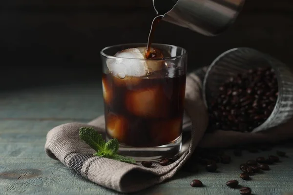 Kávé Öntése Üvegbe Jégkockákkal Mentával Babbal Világoskék Asztalon — Stock Fotó
