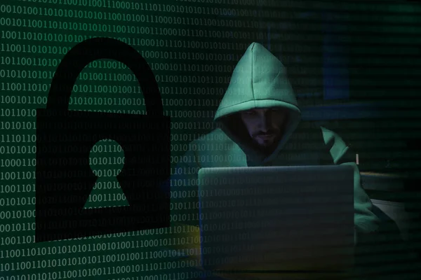 ノートパソコンとバイナリコードと暗闇の中で南京錠のイラストを持つ匿名の男 — ストック写真