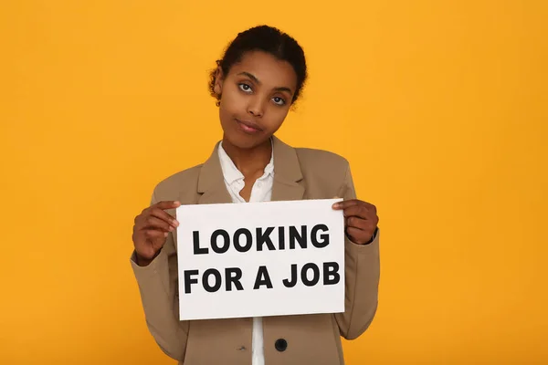 Безработная Афроамериканка Держит Табличку Фразой Ищу Работу Оранжевом Фоне — стоковое фото