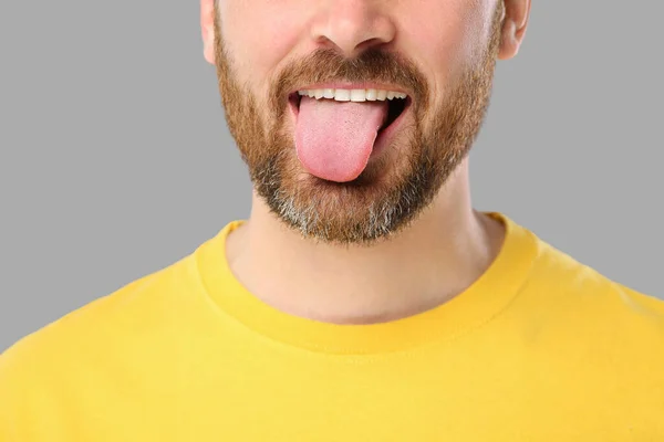 Muž Ukazující Jazyk Šedém Pozadí Detailní Záběr — Stock fotografie