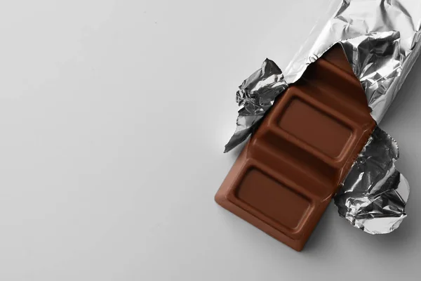 Finom Csokoládé Szelet Fóliába Csomagolva Világoskék Háttérrel Felülnézetből Szöveg Helye — Stock Fotó
