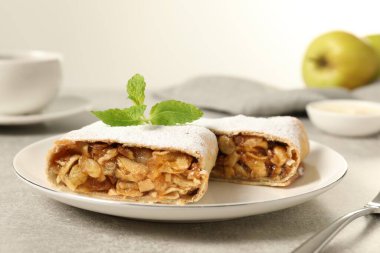 Açık gri masada elmalı, fındıklı ve kuru üzümlü lezzetli turta, yakın plan.