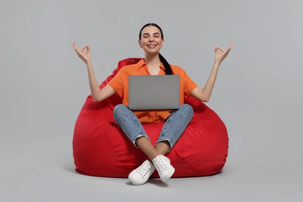 Glückliche Frau Mit Laptop Sitzt Auf Sitzsack Stuhl Und Meditiert — Stockfoto