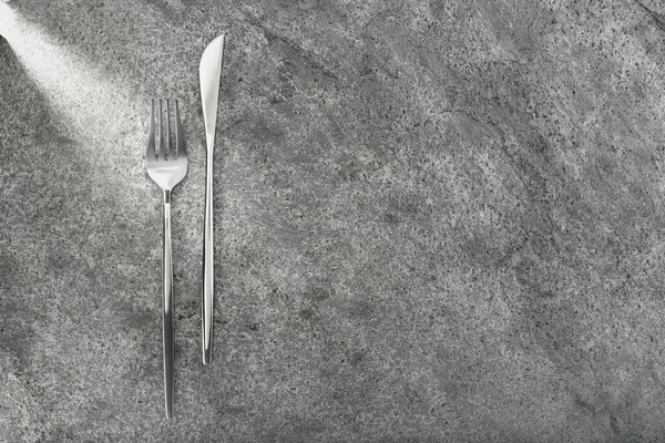 灰色桌子上的叉子和刀 平铺着 案文的篇幅 — 图库照片