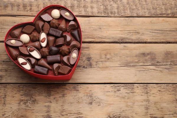 心形盒子 木制桌子上有美味的巧克力糖果 顶部尽收眼底 案文的篇幅 — 图库照片