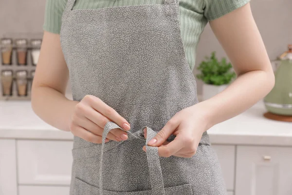 Woman Putting Grey Apron Kitchen Closeup — стоковое фото