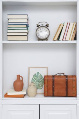 Books and different decorative elements on shelving unit indoors