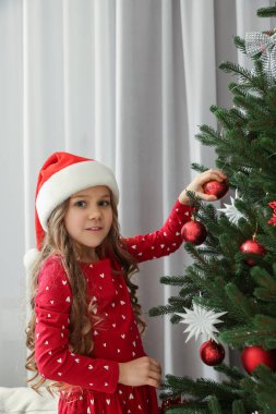 Mutlu küçük kız evde Noel ağacı dekorasyon