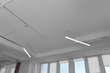 White ceiling with modern lighting in office