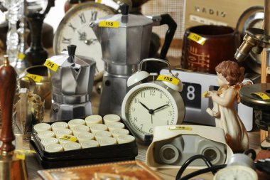 Many different items on wooden table. Garage sale