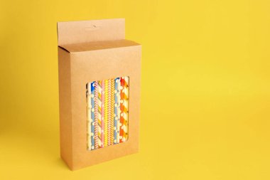 Turuncu arka planda bir sürü kağıt kamış içilen bir kutu. Metin için boşluk