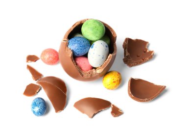 Tasty broken chocolate egg with colorful candies isolated on white