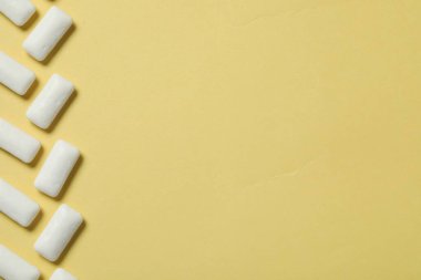 Sarı arka planda dişeti çiğneyen lezzetli, düz bir zemin. Metin için boşluk