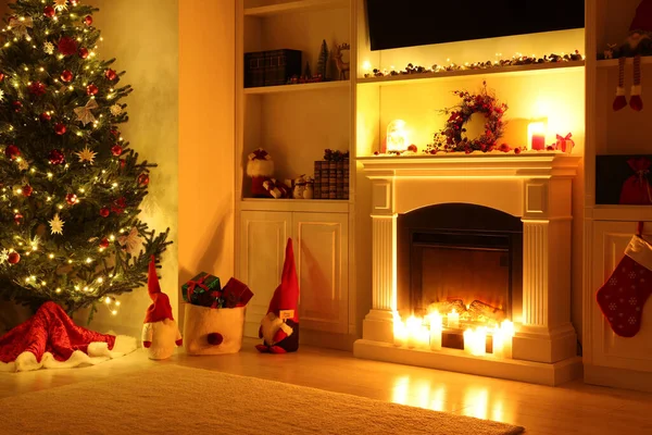 Cosy room with fireplace and burning candles in evening. Christmas atmosphere
