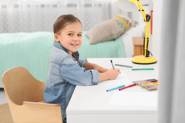 かわいい女の子の部屋に机の上にマーカーで描画します ホームワーク — ストック写真