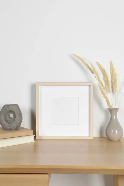 stock image Empty photo frame and vase with dry decorative spikes on wooden table. Mockup for design