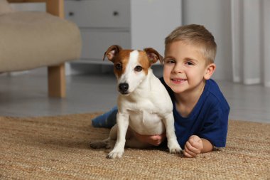 Evinde yerde sevimli köpeğiyle küçük bir çocuk, mesaj atmak için yeri var. Sevimli hayvan.