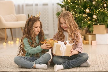 Evde Noel hediyeleri olan sevimli küçük kızlar.