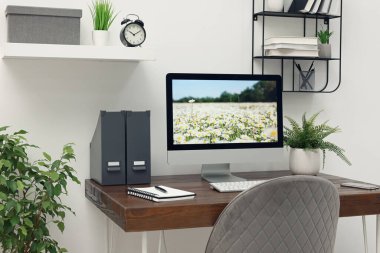 Cozy workspace with computer on wooden desk at home