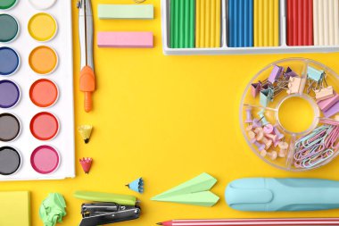 Flat lay composition with different school stationery on yellow background, space for text. Back to school