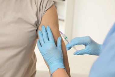 Doktor klinikteki hastaya hepatit aşısı veriyor.