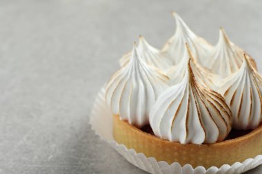 Lezzetli tatlı. Açık gri masadaki kremalı tart, yakın plan. Metin için boşluk