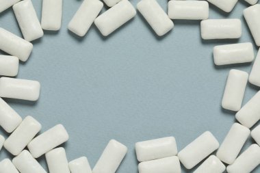 Açık mavi arkaplandaki lezzetli beyaz diş etlerinden yapılmış çerçeve düz yatıyordu. Metin için boşluk