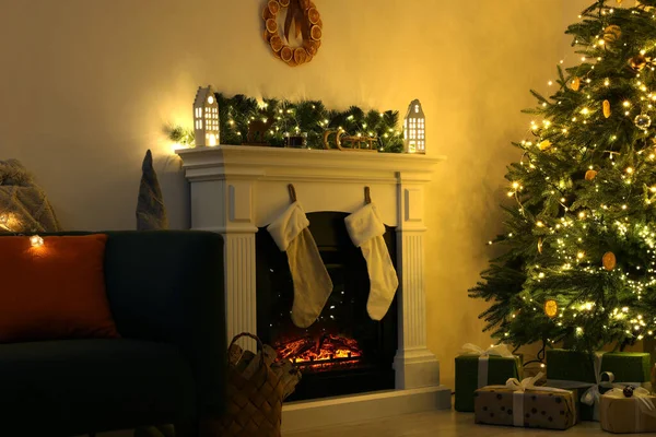 装饰圣诞树附近的时尚壁炉和舒适房间里的装饰品 — 图库照片