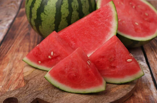 stock image Pieces of juicy ripe watermelons on wooden table, closeup