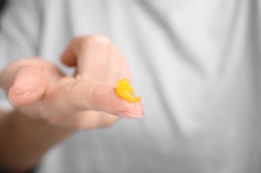 Woman with sample of cosmetic petrolatum on her finger, closeup. Space for text clipart