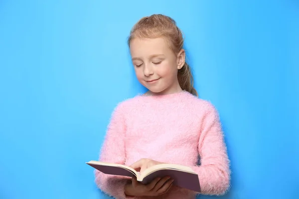 幸せな女の子読書本上のライトブルーの背景 — ストック写真